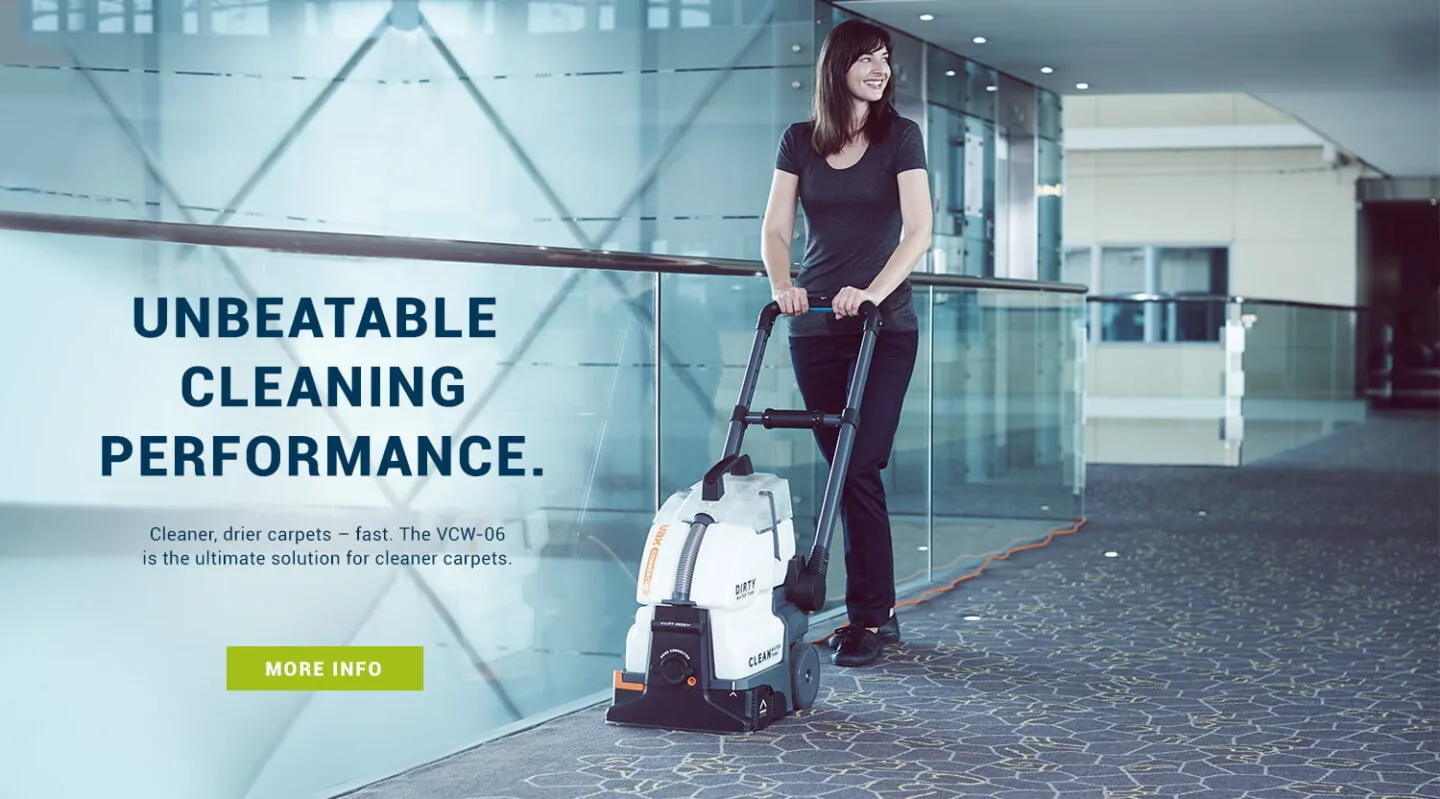 Cleaner using Vax commercial carpet washer in a corridor for campaign photography